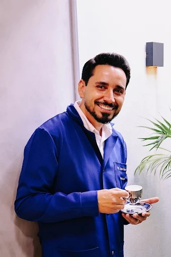 Dr. João Marcos sorrindo, com seu jaleco azul