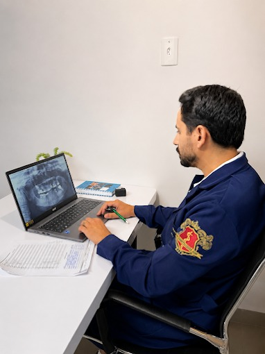 Dr. João Marcos analisando uma radiografia para planejar um tratamento